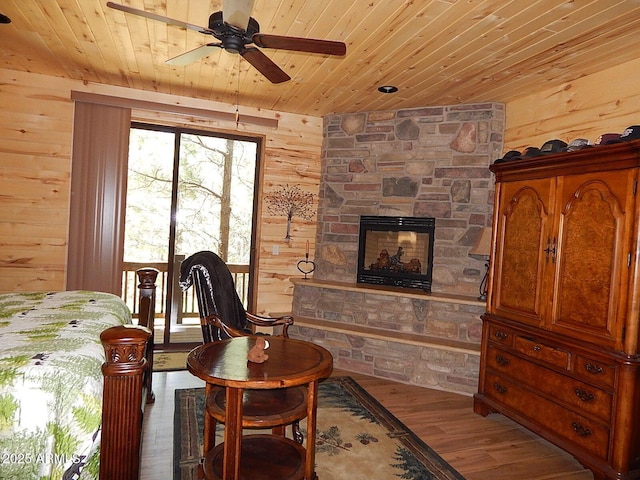 2372 Summer Loop, Forest Lakes, AZ 85931 - living room featuring wood ceiling, wood walls, ceiling fan, wood finished floors, and a fireplace