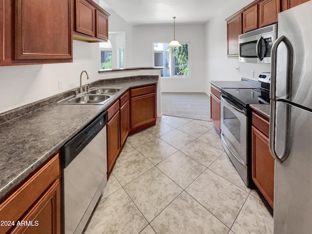 kitchen with pendant lighting, appliances with stainless steel finishes, sink, and light tile patterned floors