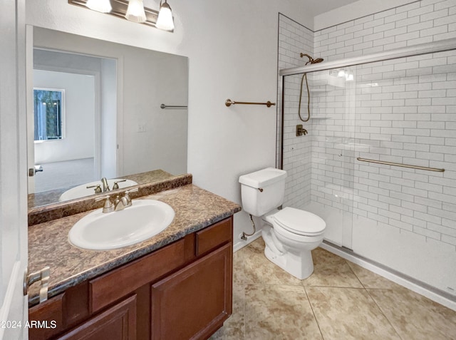 bathroom featuring vanity, toilet, an enclosed shower, and tile patterned flooring