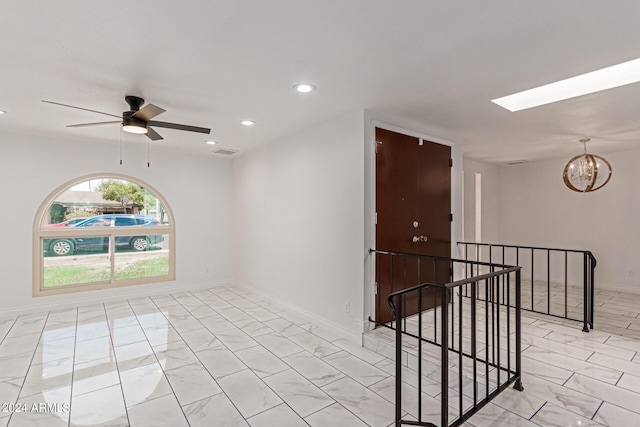 unfurnished room with a skylight, baseboards, visible vents, marble finish floor, and recessed lighting