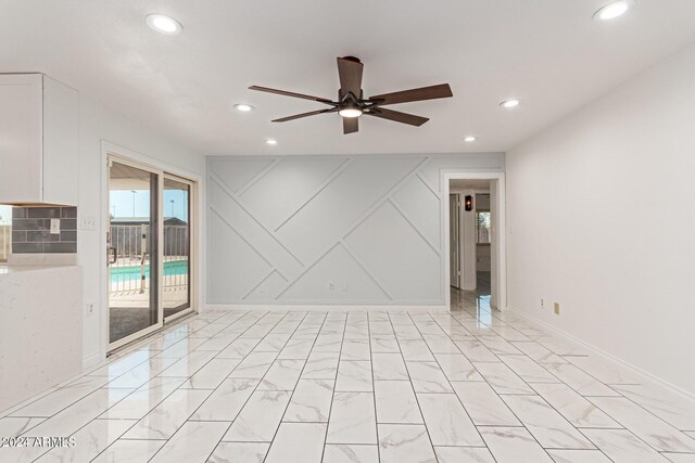 unfurnished room featuring a ceiling fan, recessed lighting, marble finish floor, and baseboards