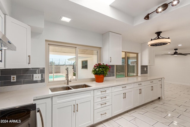 kitchen featuring stainless steel electric range oven, a sink, white cabinetry, and decorative backsplash