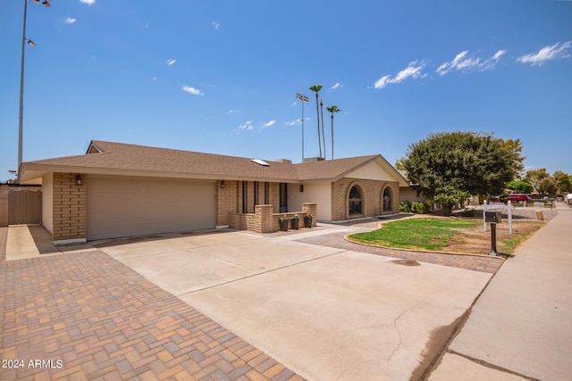 single story home featuring brick siding, driveway, and an attached garage