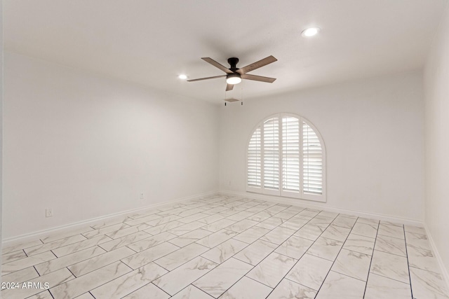 empty room with marble finish floor, ceiling fan, baseboards, and recessed lighting