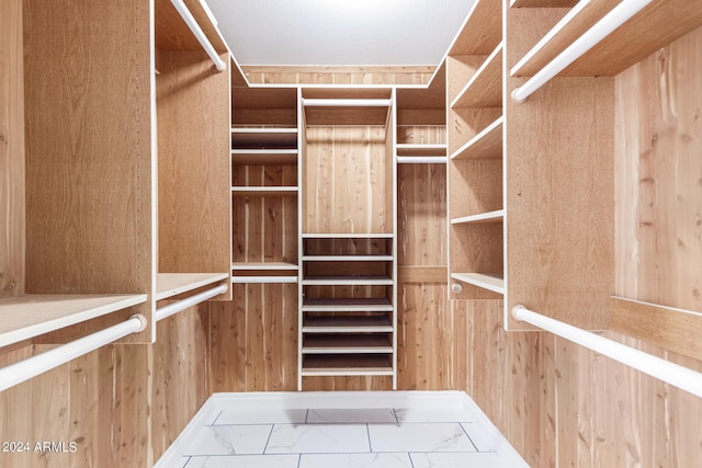 spacious closet featuring marble finish floor