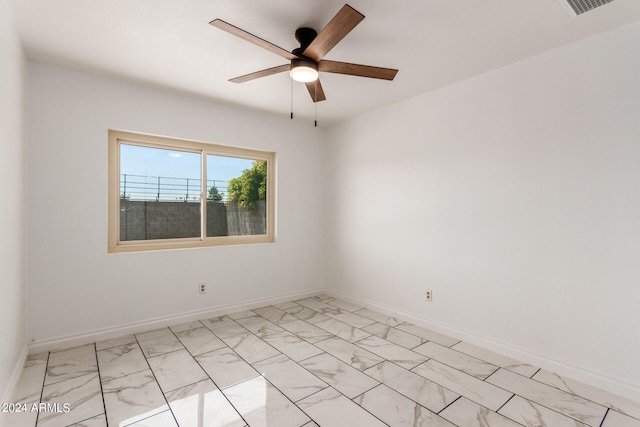 unfurnished room featuring marble finish floor, baseboards, and a ceiling fan