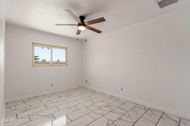 unfurnished room with marble finish floor, visible vents, ceiling fan, and baseboards