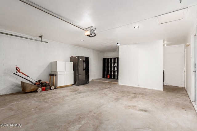 garage featuring freestanding refrigerator and a garage door opener