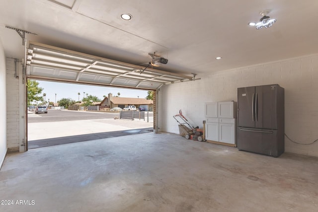 garage with freestanding refrigerator and a garage door opener