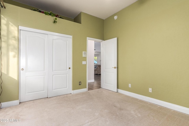 unfurnished bedroom with a closet, carpet, and baseboards