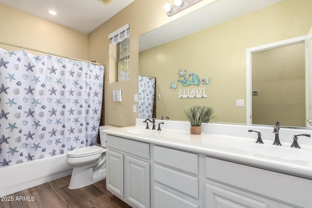 bathroom with double vanity, a sink, wood finished floors, and toilet