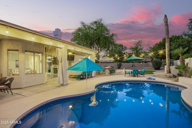 view of swimming pool featuring outdoor dining space, a fenced in pool, a fenced backyard, and a patio area