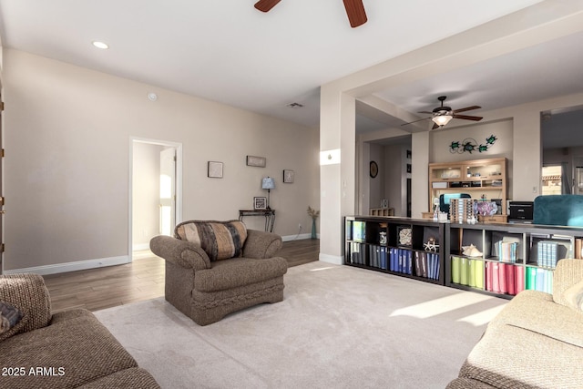 living area featuring baseboards, a ceiling fan, wood finished floors, and visible vents