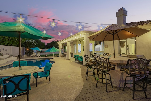 view of patio with a fenced in pool, outdoor dry bar, and fence private yard