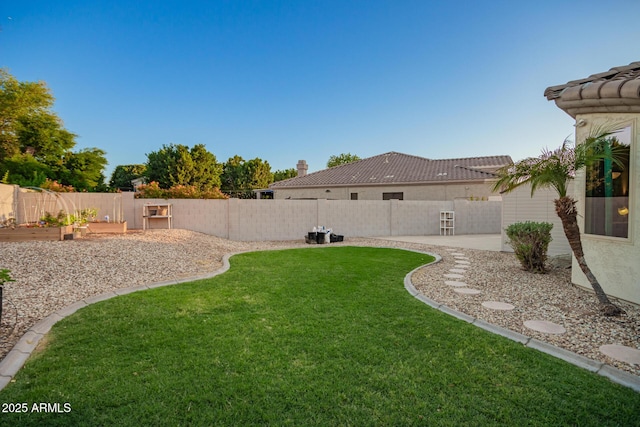 view of yard featuring a fenced backyard and a garden