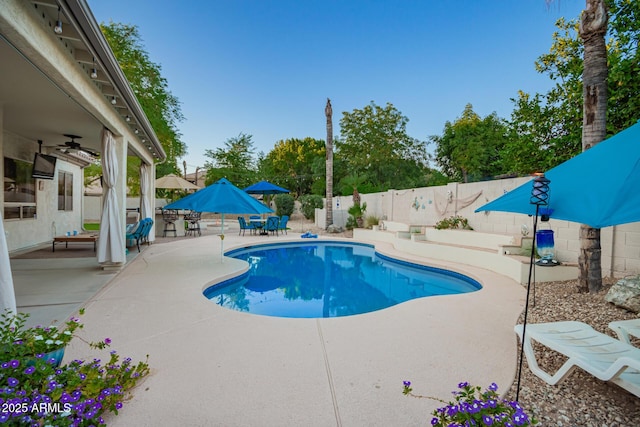 view of swimming pool with outdoor dining space, a fenced backyard, a fenced in pool, a ceiling fan, and a patio