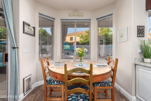 dining space featuring baseboards and dark wood finished floors