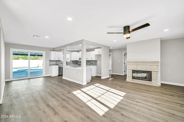 unfurnished living room featuring ceiling fan, light hardwood / wood-style floors, and a tile fireplace