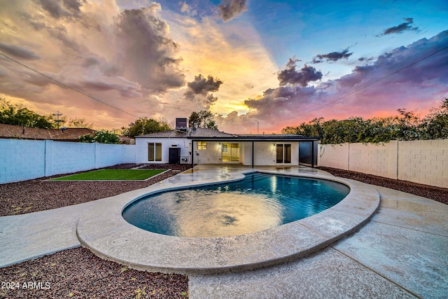 pool at dusk with a patio