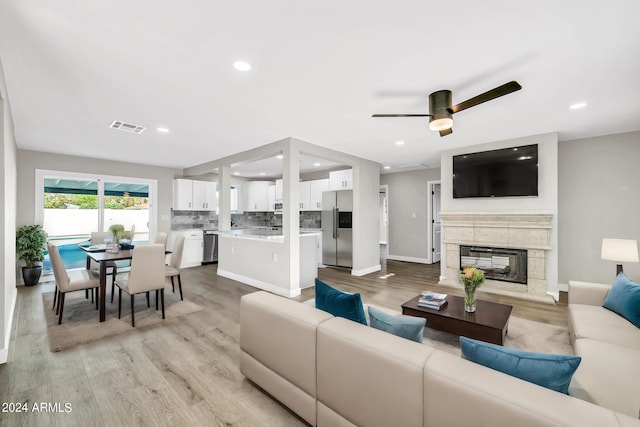 living room with light hardwood / wood-style flooring and ceiling fan