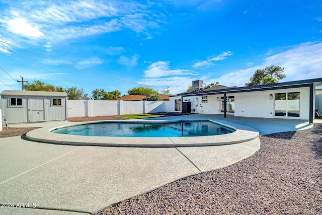 view of swimming pool featuring a patio and a storage unit