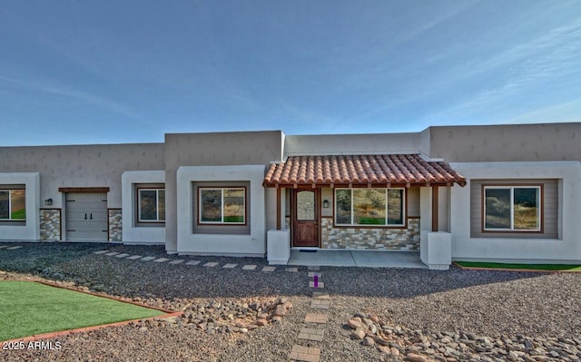 pueblo-style house featuring a garage