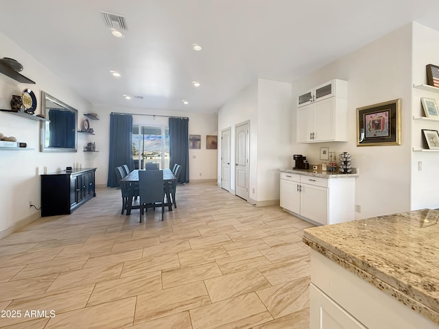 kitchen with light stone countertops and white cabinets