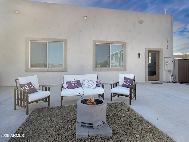 patio terrace at dusk featuring a fire pit