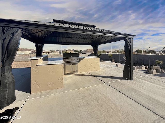 view of patio / terrace with exterior kitchen, a gazebo, and grilling area