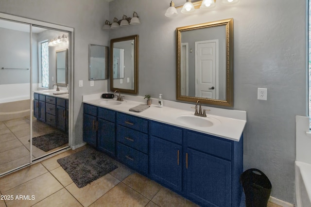 bathroom featuring a washtub, tile patterned flooring, and vanity