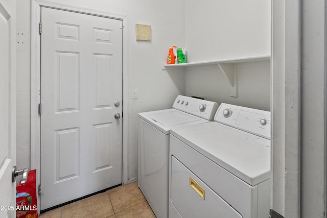 laundry room with washer and dryer and light tile patterned floors