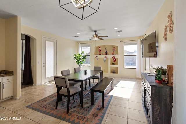 tiled dining room featuring ceiling fan, a wealth of natural light, and built in shelves