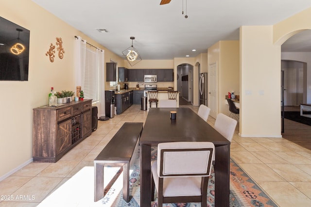 dining area with ceiling fan, sink, and light tile patterned floors