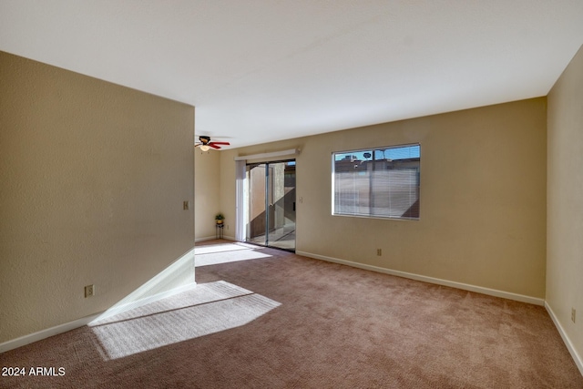 spare room featuring light carpet and ceiling fan