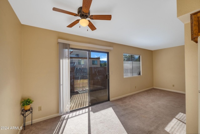 carpeted spare room featuring ceiling fan