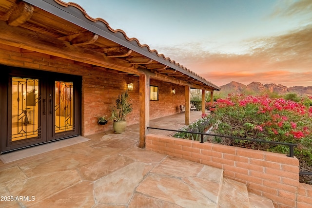 patio terrace at dusk with a mountain view and french doors