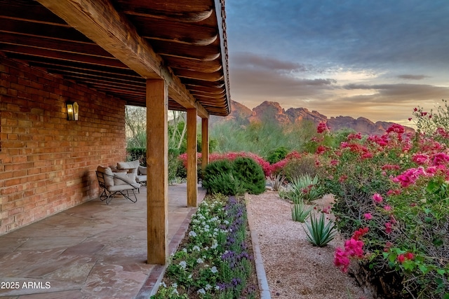 patio terrace at dusk featuring a mountain view