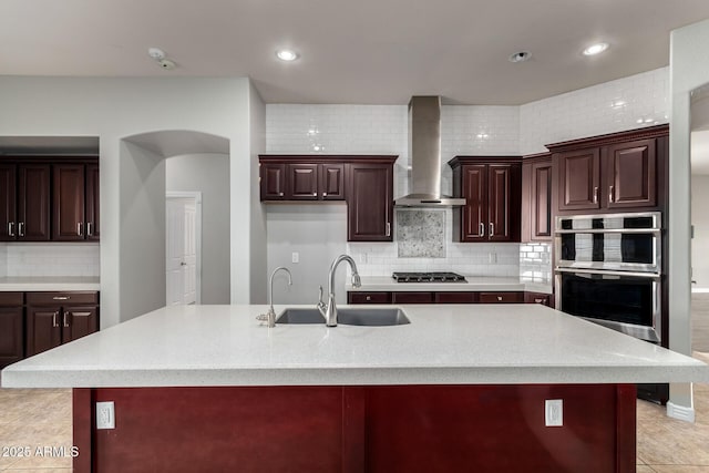 702 E Capricorn Way, Chandler, AZ 85249 - kitchen featuring wall chimney range hood, a sink, tasteful backsplash, a large island with sink, and recessed lighting