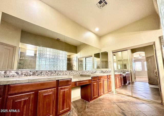 702 E Capricorn Way, Chandler, AZ 85249 - bathroom featuring double vanity, a tile shower, and tasteful backsplash