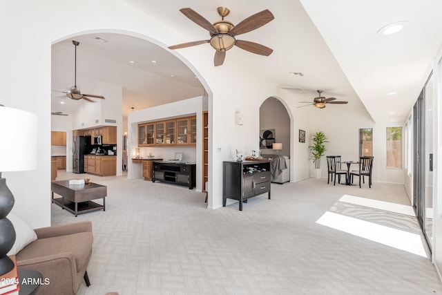 living room with light carpet, high vaulted ceiling, and ceiling fan