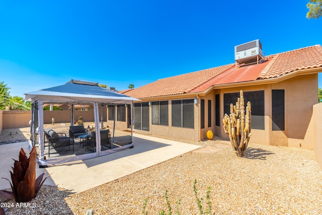 rear view of house featuring cooling unit, a gazebo, an outdoor living space, and a patio