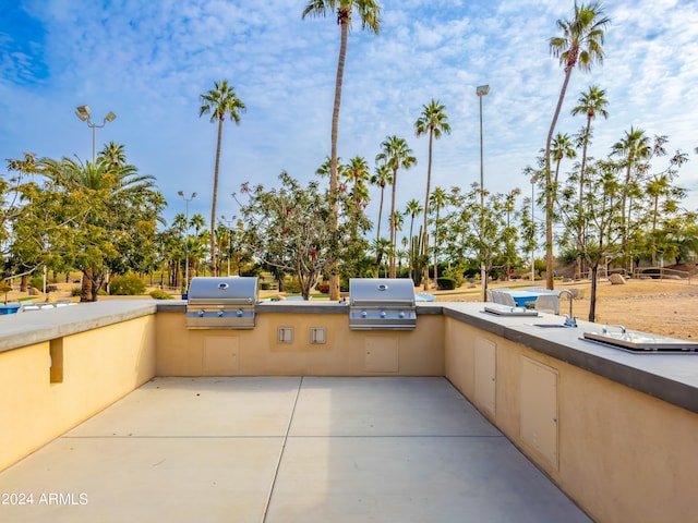 view of patio featuring exterior kitchen, a grill, and sink