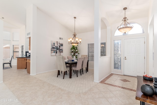 tiled entrance foyer with high vaulted ceiling and a notable chandelier