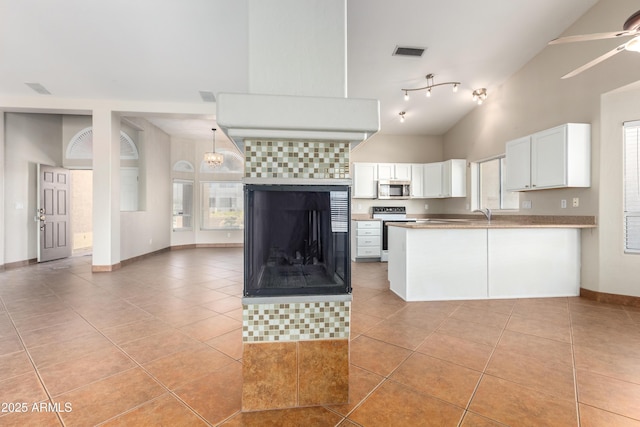 kitchen with appliances with stainless steel finishes, white cabinetry, visible vents, and light tile patterned floors