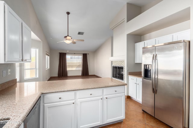 kitchen featuring light tile patterned floors, visible vents, appliances with stainless steel finishes, white cabinetry, and a peninsula