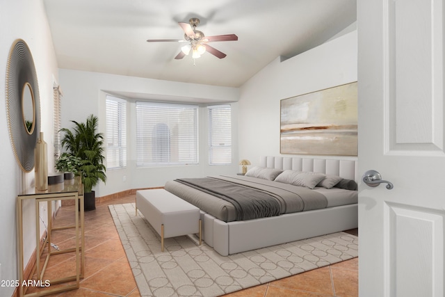 bedroom featuring lofted ceiling, light tile patterned floors, ceiling fan, and baseboards