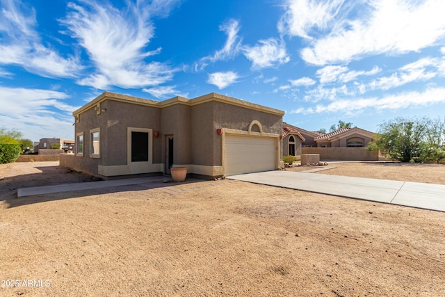 view of front of home with a garage, concrete driveway, and stucco siding