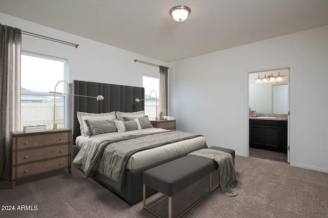 bedroom with dark carpet and ensuite bath