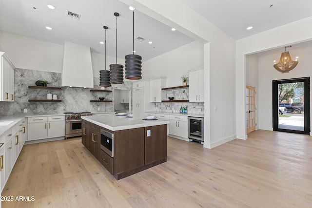 9611 E Clinton St, Scottsdale, AZ 85260 - kitchen with open shelves, designer stove, wine cooler, dark brown cabinets, and light countertops