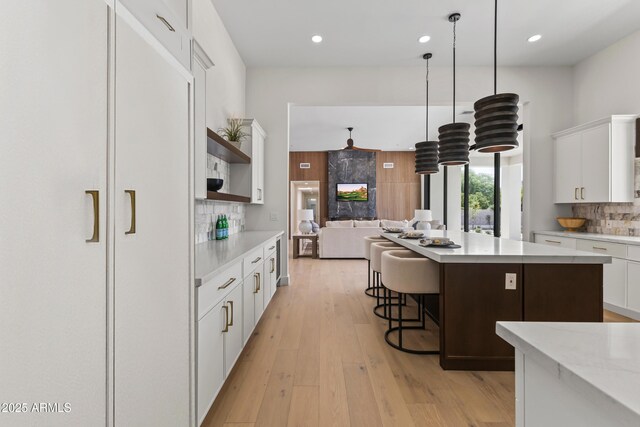 9611 E Clinton St, Scottsdale, AZ 85260 - kitchen with open shelves, decorative backsplash, white cabinetry, light countertops, and a center island